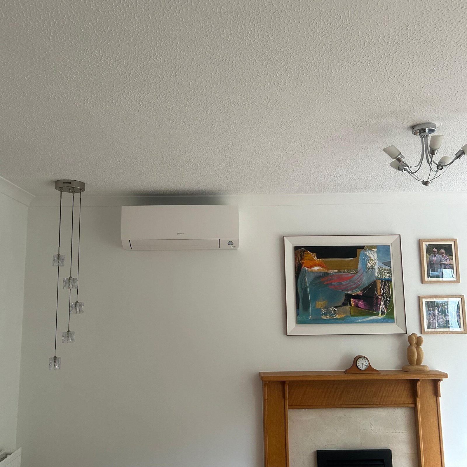 Slimline air conditioning unit installed above a fireplace in a period property